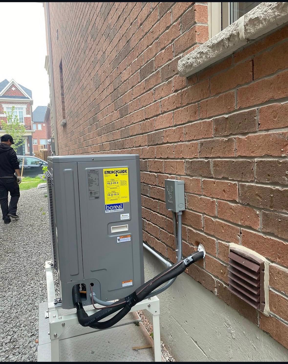 Energy-efficient central air conditioner installed beside a home